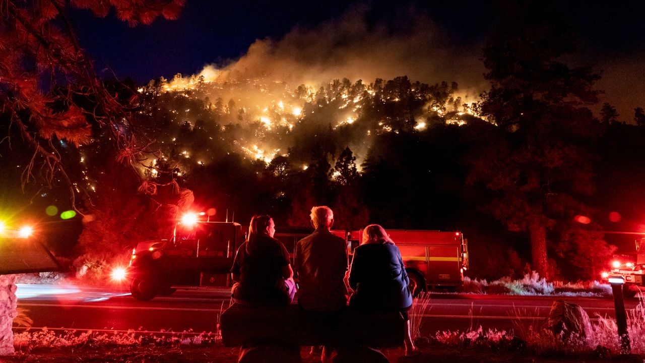 Residents watch part of the Sheep Fire burn through a hillside near their homes in Wrightwood, California, on June 11, 2022. 